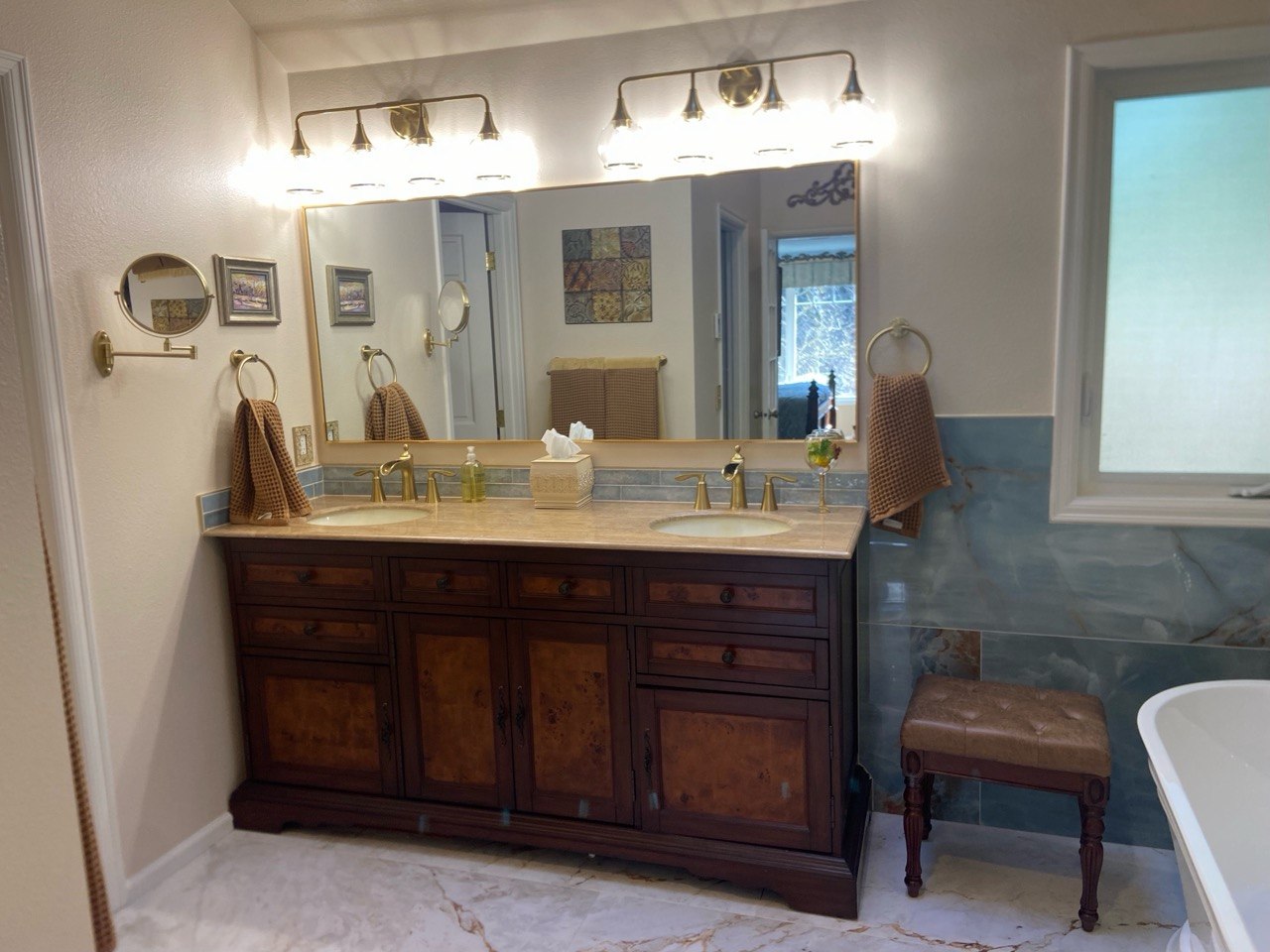 Freestanding tub beside glass shower with onyx tile